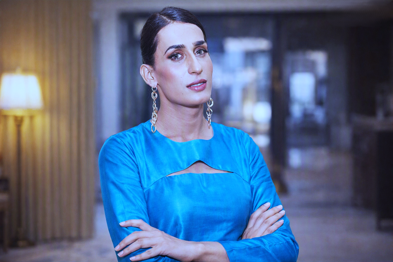Professional actress in blue top with crossed arms