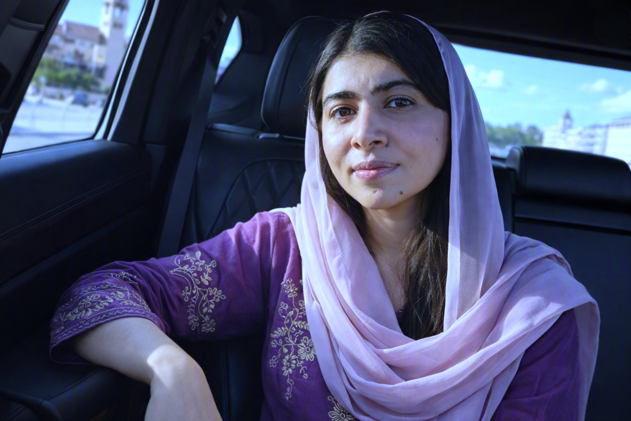 Purple kurti aur light pink dupatta pehne car ke andar baithe hue