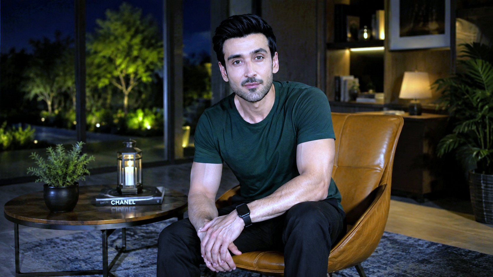 Green shirt mein larka chair par baitha hai