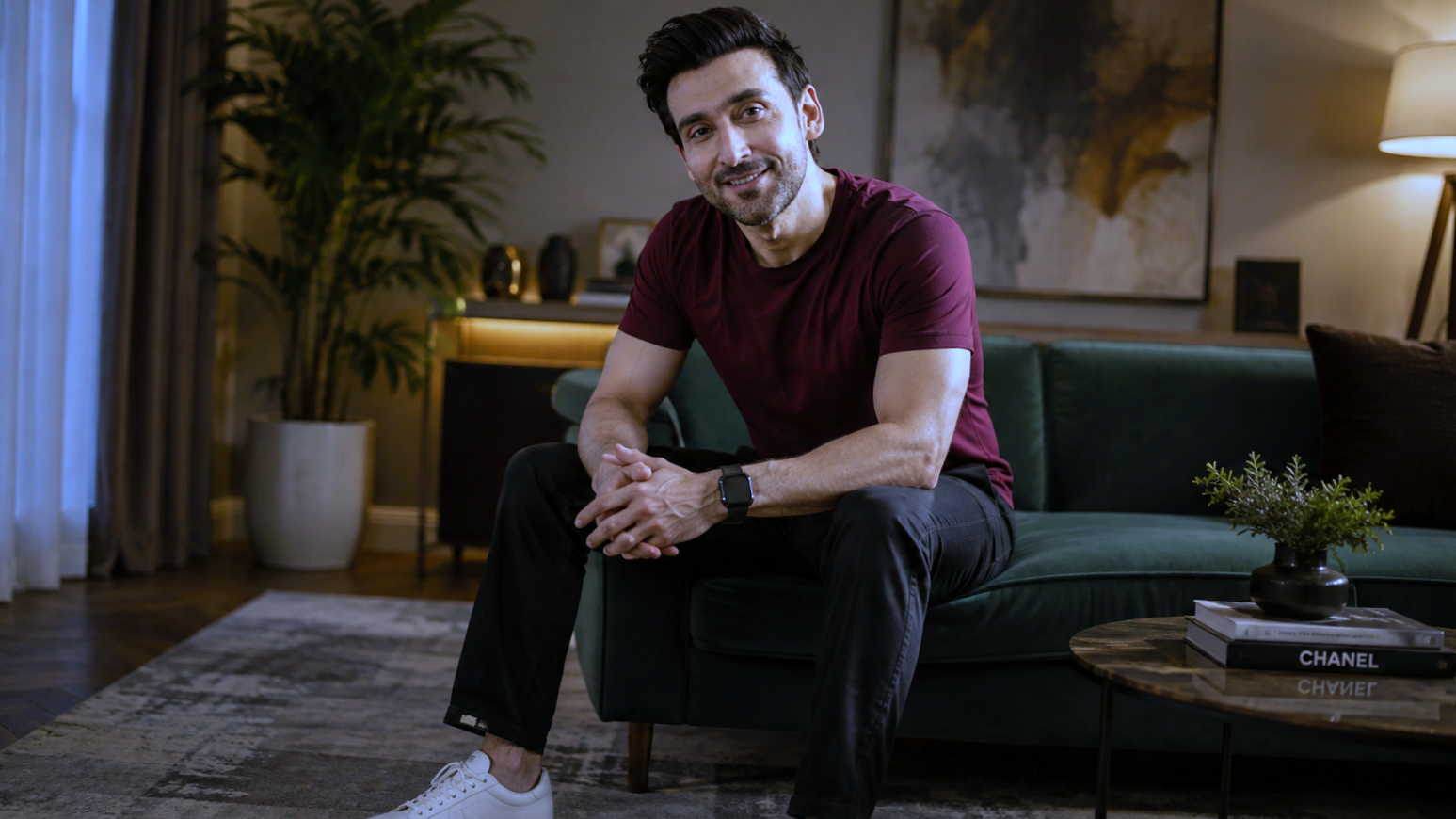 Maroon shirt mein larka sofa par baitha hai