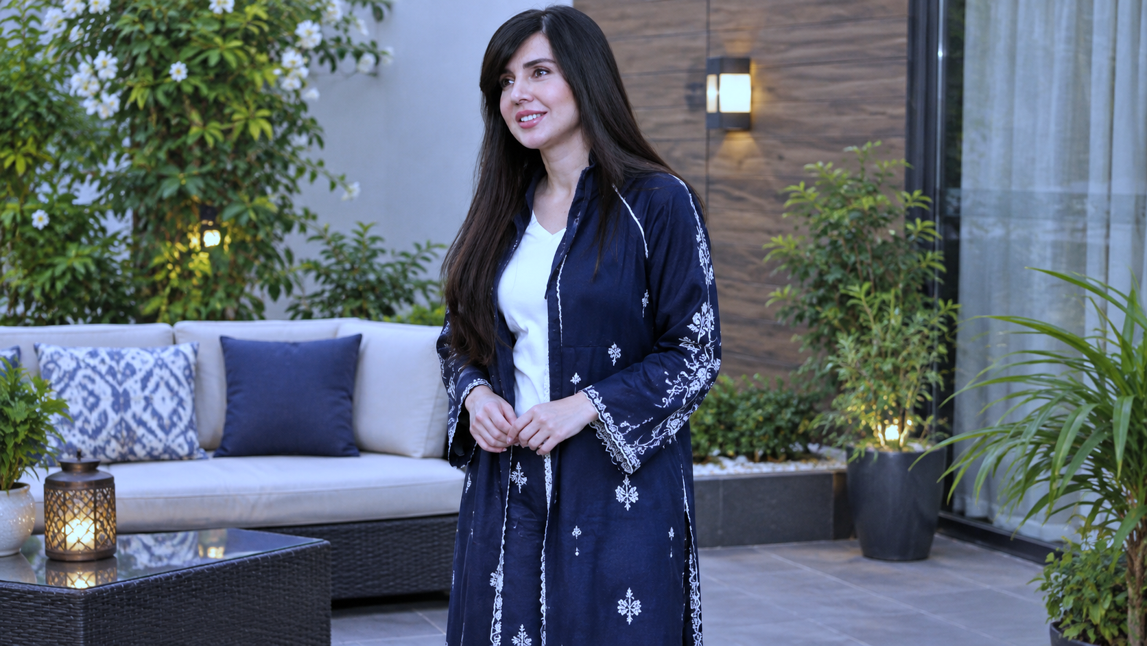 Style icon dark blue embroidered long dress mein outdoor patio par khari hui