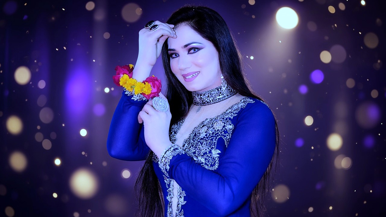 Stage super-star bright blue outfit aur choker necklace mein background lights ke sath