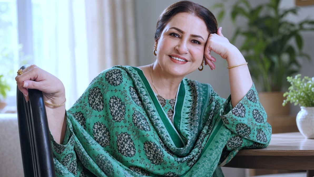 Veteran actress green printed dress mein chair par baithi hu