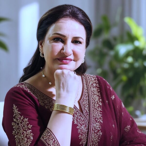 Pakistani television star maroon suit mein indoor studio mein
